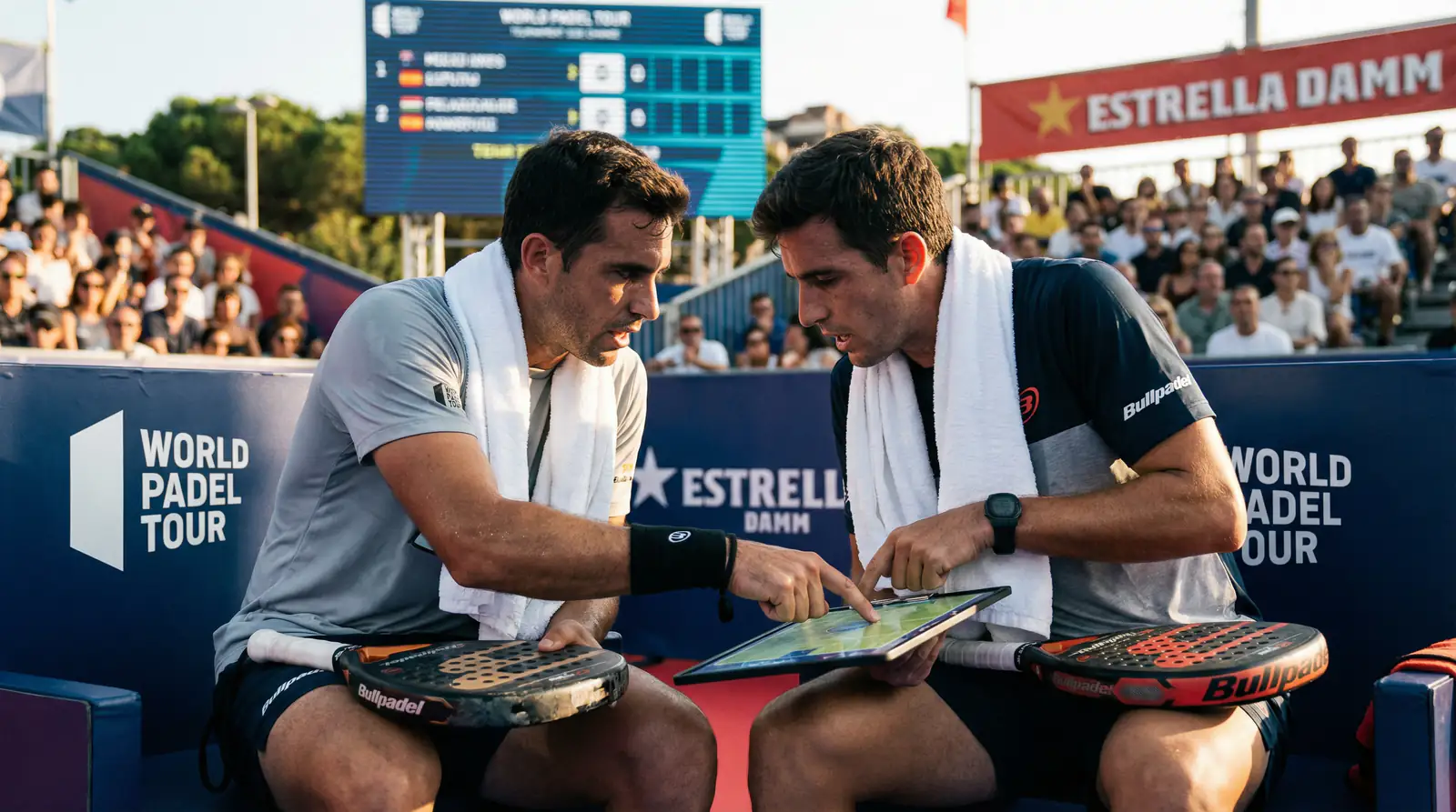 Pareja de pádel profesional comunicándose durante un cambio de lado en un torneo